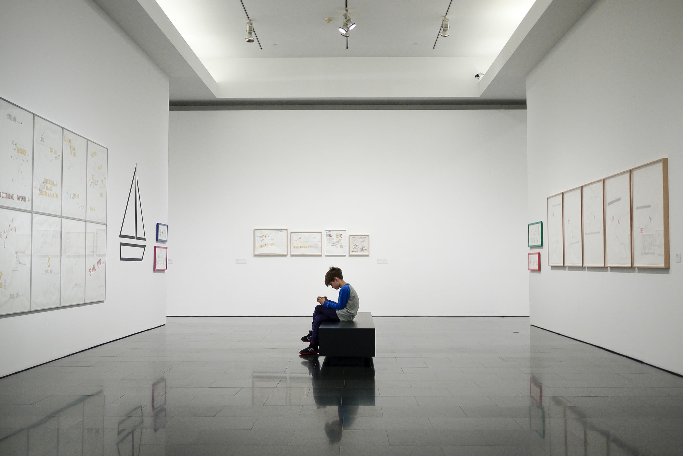 man sitting near museum painting